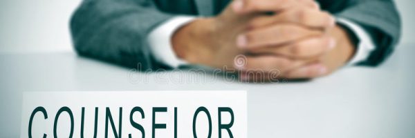 counselor-man-wearing-suit-sitting-desk-desktop-nameplate-front-him-word-38329308