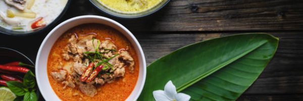 Most famous Thai foods; red curry pork, green curry pork, chicken coconut soup or Thai in names "Panang", "Kaeng Keaw Whan" and Tom Kha Gai. top view on wooden background.