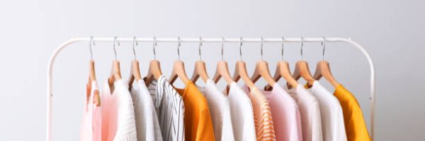 fashion clothes on a rack in a light background indoors. place for text