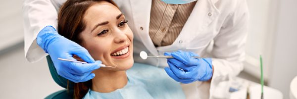 Happy woman having her teeth checked during appointment at dental clinic.