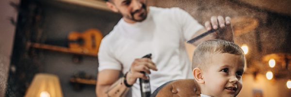 Cute little boy at the barber shop getting his hairut