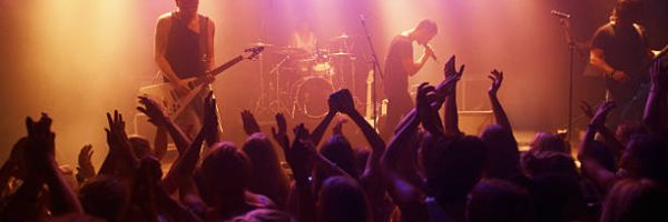 A band playing their hearts out at a festival show. This concert was created for the sole purpose of this photo shoot, featuring 300 models and 3 live bands. All people in this shoot are model released.