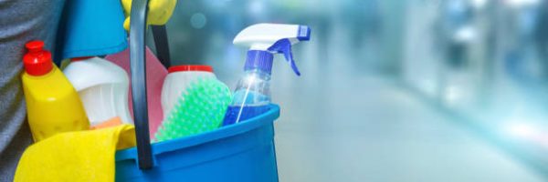 Cleaning lady with a bucket and cleaning products on blurred background .